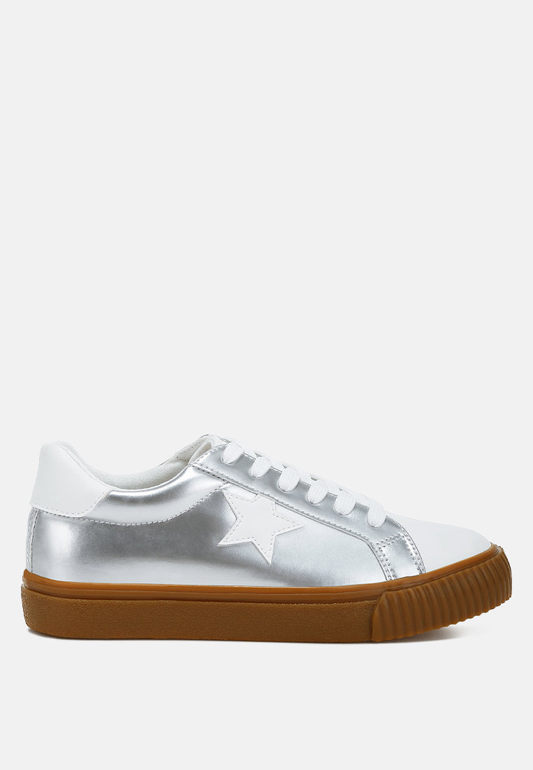 London Rag metallic faux leather star sneakers, showing a person jumping in stylish, shiny sneakers with star details.