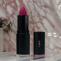 Pink Pizzazz lipstick by Cad b with beeswax for hydration, cruelty-free and paraben-free, shown in a sleek tube.